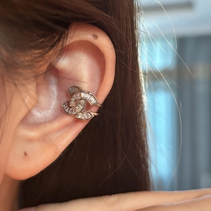 Makroaufnahme von Silber-Ohrmanschette mit Zirkonia und Doppel-C-Design am Ohr