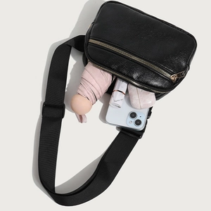 Black pebbled leather fanny pack with gold zippers and adjustable strap for daily use