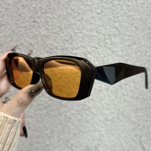 Detail of vintage polygonal black frame sunglasses with amber lenses and angular temples