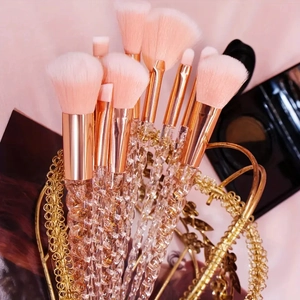 Artistic display of 10-piece makeup brush set with crystal spiral handles in a gold basket