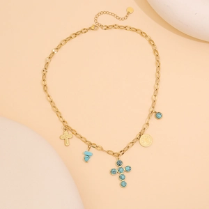 Détail d'un collier doré avec pierre turquoise, croix et pendentifs en or