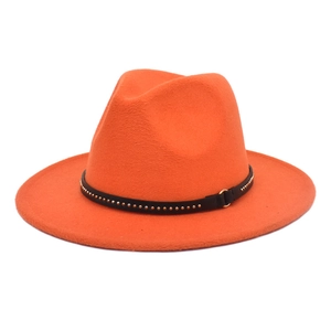 Detail of orange wool fedora hat featuring a black leather band with gold metal studs
