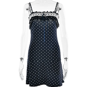 Deep blue polka dot mini dress with white lace trim and straps on studio mannequin