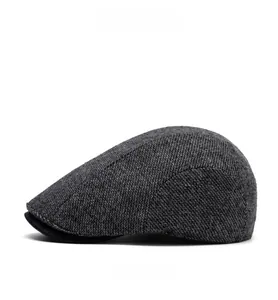 Side view of dark gray wool newsboy flat cap showing classic herringbone texture