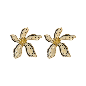 Vintage-style enamel flower earrings with cream petals, gold trim, and black dots on white background