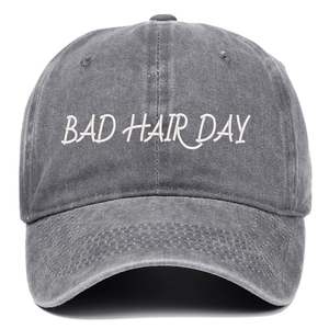 Détail de la broderie BAD HAIR DAY blanche sur casquette de baseball grise délavée