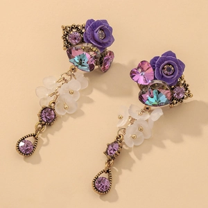 Detail of vintage flower drop earrings with purple resin roses and crystal accents