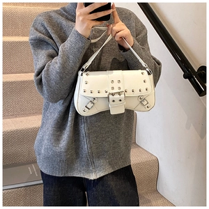 Close-up of white PU leather punk shoulder bag with silver rivets and buckle details