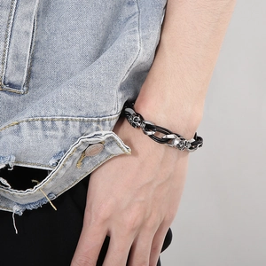 Detail eines Herren-Lederarmbands im Punk-Stil mit Totenkopf und Rose am Handgelenk
