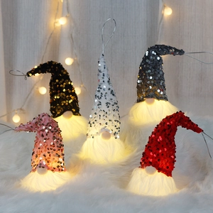 Lighted sequin Christmas gnome ornaments in five colors on a festive white fur background