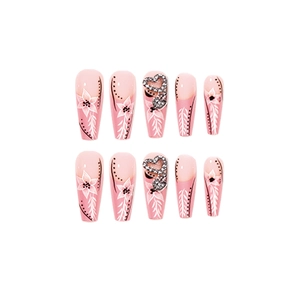 Faux ongles français roses avec motifs floraux, strass brillants et forme cercueil long