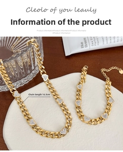 Detail of gold heart pendant necklace and bracelet set with rhinestones on a tray