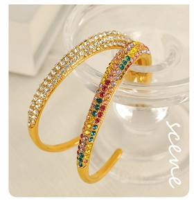 Detail of gold-plated open bangles featuring rainbow and white pavé cubic zirconia