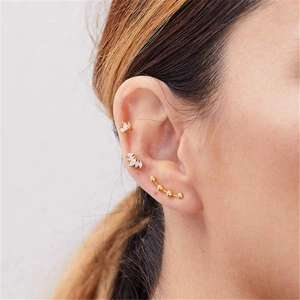 Gros plan de boucles d'oreilles en argent S925 doré avec fleurs et zircons sur modèle