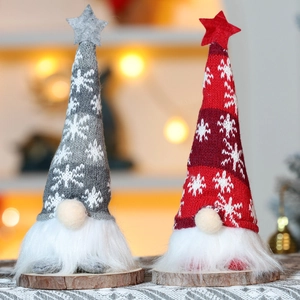 Close-up of knit Christmas gnomes with white faux fur beards on natural wood bases