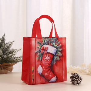 Red Christmas non-woven gift bag with holiday stocking prints and top handles