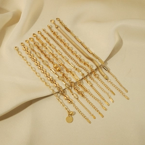 Set of punk style chunky chain bracelets with 18K gold plating on beige fabric backdrop