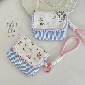 Detailed macro view of floral quilted cotton pouch with thick woven strap and soft lining