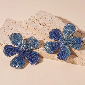 Macro detail of luxury flower earrings featuring blue and purple gradient rhinestones