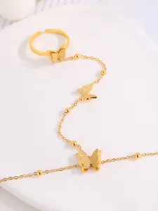 Detail of gold butterfly bracelet ring set with matte charms and polished gold beads