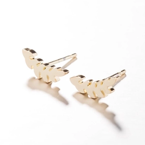 Macro shot of gold leaf-shaped stud earrings with intricate texture on white background