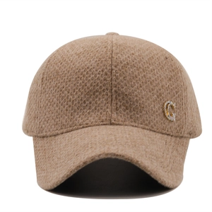 Close-up of khaki corduroy baseball cap featuring a sparkling rhinestone letter G detail