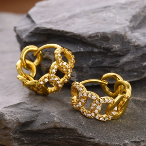 Detail shot of gold curb chain hoop earring with micro-pave cubic zirconia on slate
