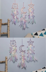Detailed view of cat, moon and star shaped dreamcatchers with pink feathers and LED lights