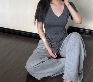 Detail view of slim fit V-neck grey T-shirt with matching drawstring joggers on a model
