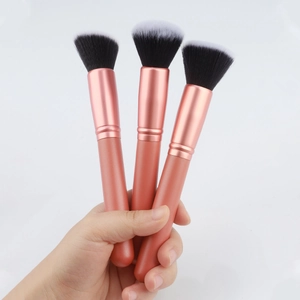 Three-piece rose gold makeup brush set with foundation, powder, and contour brushes