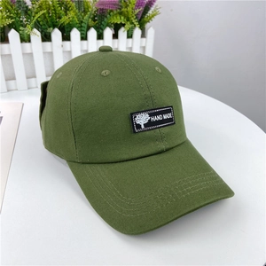 Detail view of olive green cotton baseball cap with Hand Made patch and decorative brim stitching