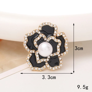 Vue détaillée de la broche fleur camélia dorée avec perle blanche et strass brillants