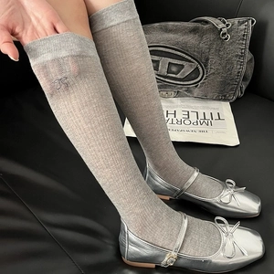 Grey ballet-style knit calf socks with embroidered bow details for a stylish spring look