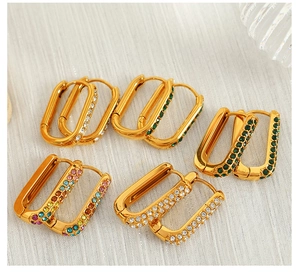 Detailed flat lay of five pairs of geometric gold-plated earrings with colorful zircon