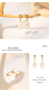 Detailed macro view of retro 18k gold pearl drop earrings with polished finish
