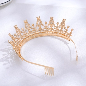 Detailed view of intricate gold bridal tiara with sparkling rhinestones on white fabric