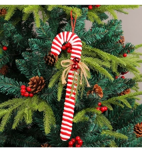Close-up of plush red and white striped candy cane ornament on a Christmas tree