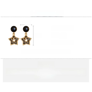 Détail des boucles d'oreilles étoiles avec strass noirs indiquant une longueur de 3,4 cm
