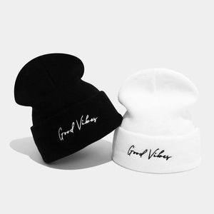 Set of black and white knitted beanies featuring Good Vibes embroidery on the folded cuffs
