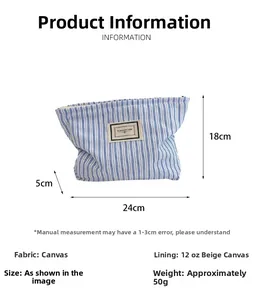 Detailed view of the blue striped canvas pouch featuring a rectangular logo and zip closure