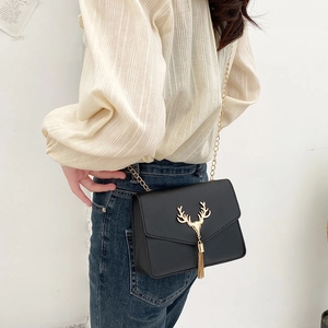 Retro black crossbody bag with gold deer head clasp and tassel on a chain strap