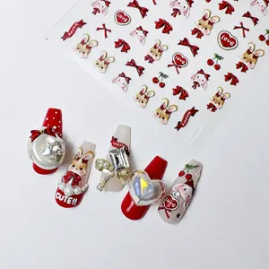 Close-up of Japanese embossed nail stickers featuring cute red rabbits and bow designs
