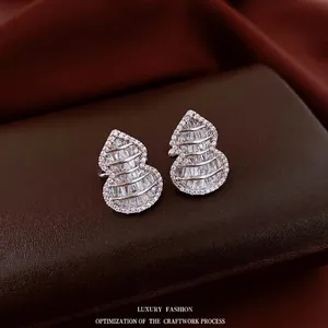 Silver gourd-shaped ear cuffs with zircon pavé setting on a premium velvet background