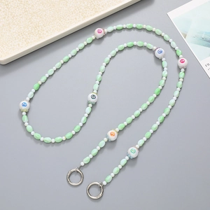 Detail of light green and white acrylic beaded phone strap with colorful numeric charms