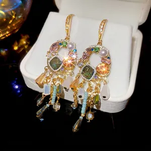 Vintage gold tassel earrings with colorful crystals and pearls in luxury jewelry box