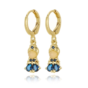 Detail of gold doll earring featuring blue rhinestones and sapphire teardrop pendant