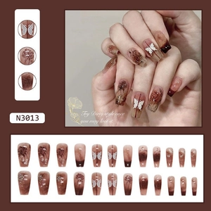 Detail of long ballerina nails with coffee brown marble, 3D butterfly, and rose patterns