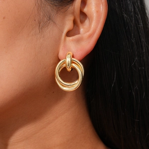 Minimalist double gold circle hoop earrings with textured finish on a female model