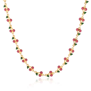 Detailed close-up of golden necklace with pink glitter cherries and green enamel leaves