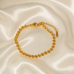 18k gold plated stainless steel hollow heart link bracelet on white silk fabric